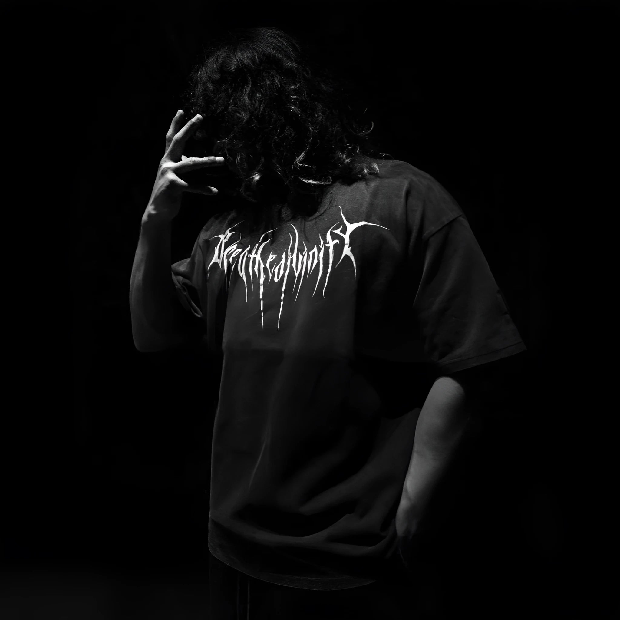 Man's loose-fit dark cotton t-shirt with short sleeves and metallic gilding detail on the front.