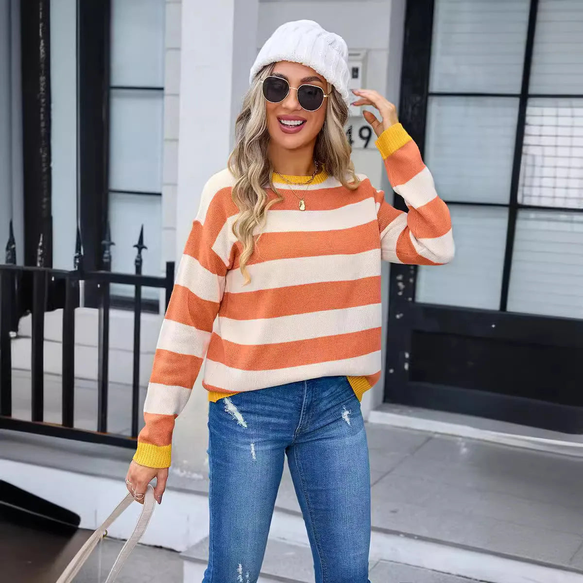 Women's loose fit acrylic knit sweater in blue with striped pattern, long sleeves and round neck.