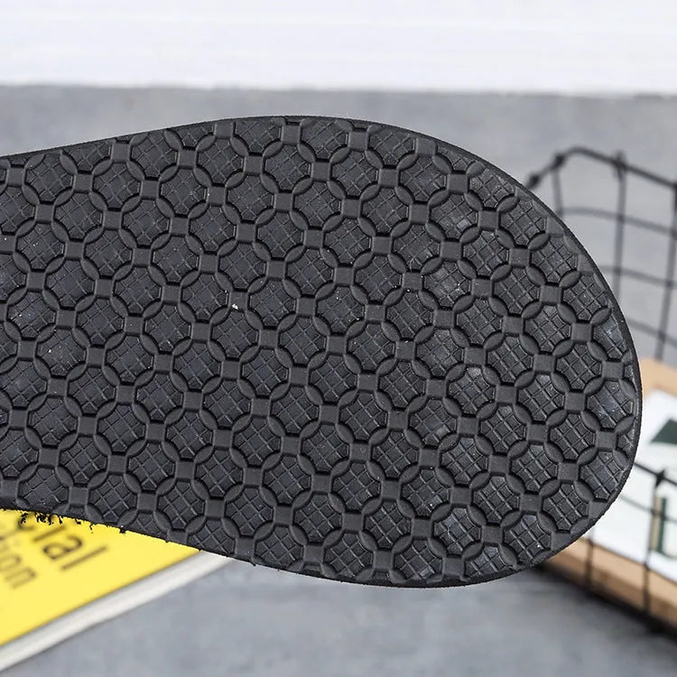 Women's brown bohemian slippers with an adjustable woven strap and a raised rubber sole.