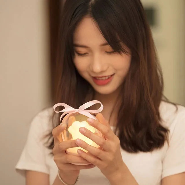 Cute grey or pink cat paw shaped USB rechargeable night light with music box on a desk.