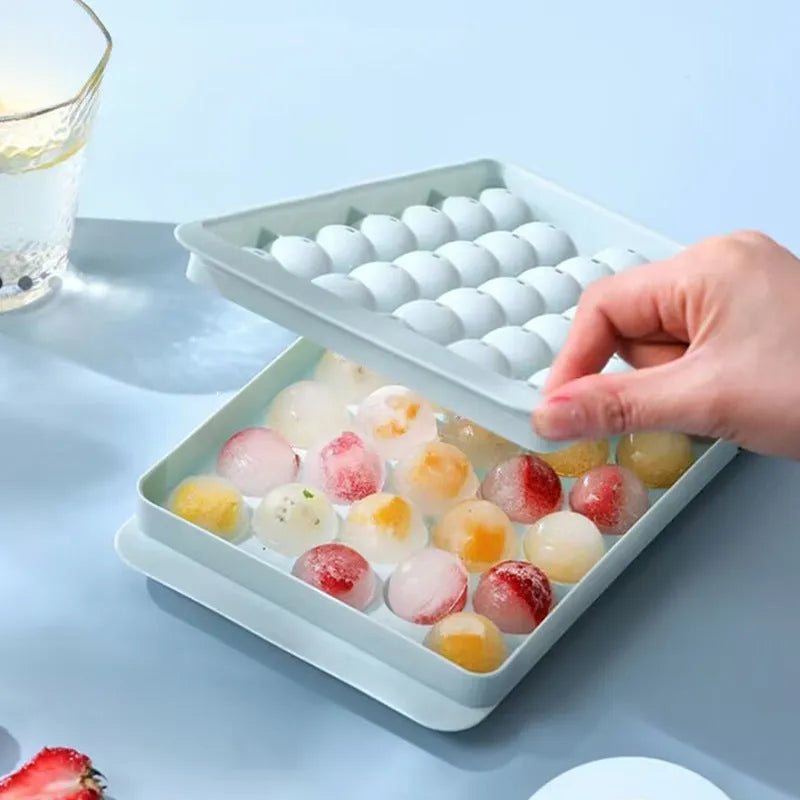 Blue silicone ice cube tray with lid showing 33 round moulds for large ice cubes