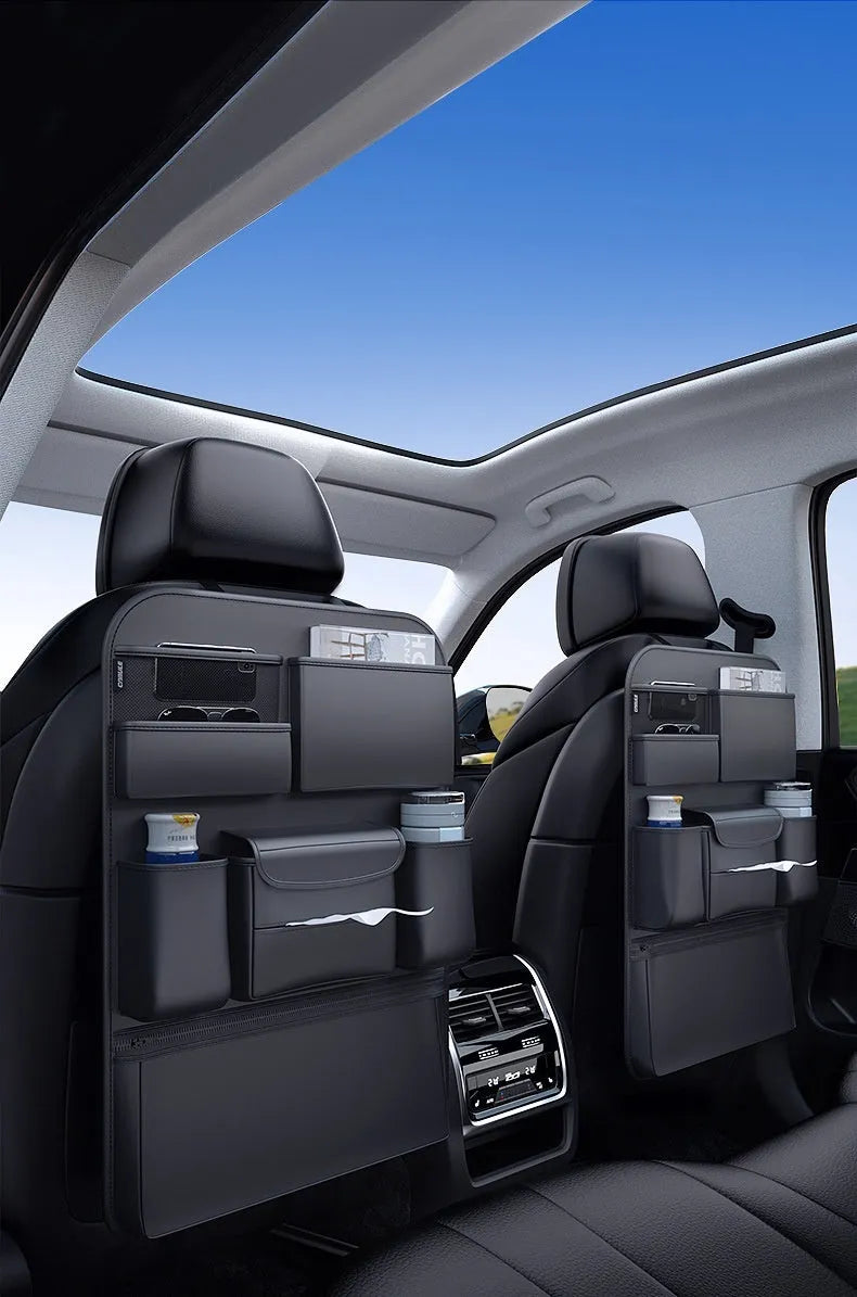 Black leather car seat back storage hanging bag with handle shown behind vehicle seat