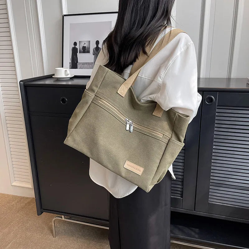 Canvas shoulder bag for women in khaki with stitching detail, open front pocket, and double shoulder straps