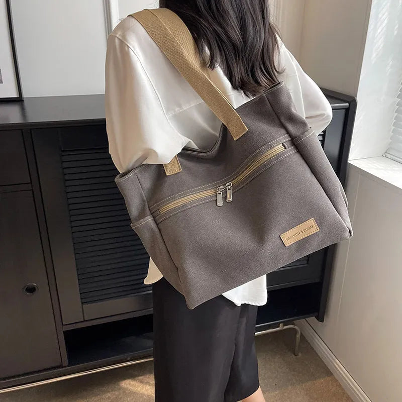 Canvas shoulder bag for women in khaki with stitching detail, open front pocket, and double shoulder straps
