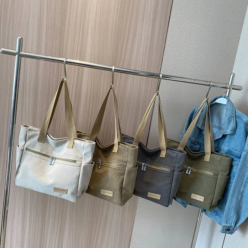Canvas shoulder bag for women in khaki with stitching detail, open front pocket, and double shoulder straps