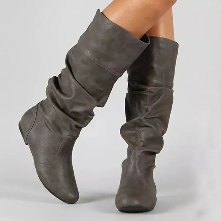 Women's black slip-on flat boots with a round toe and high cylinder shaft.