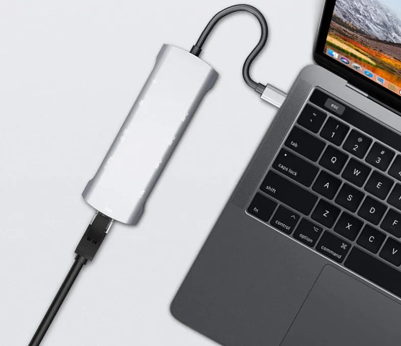 Grey aluminium USB-C docking station with HDMI, VGA, USB 3.0, and PD charging ports.