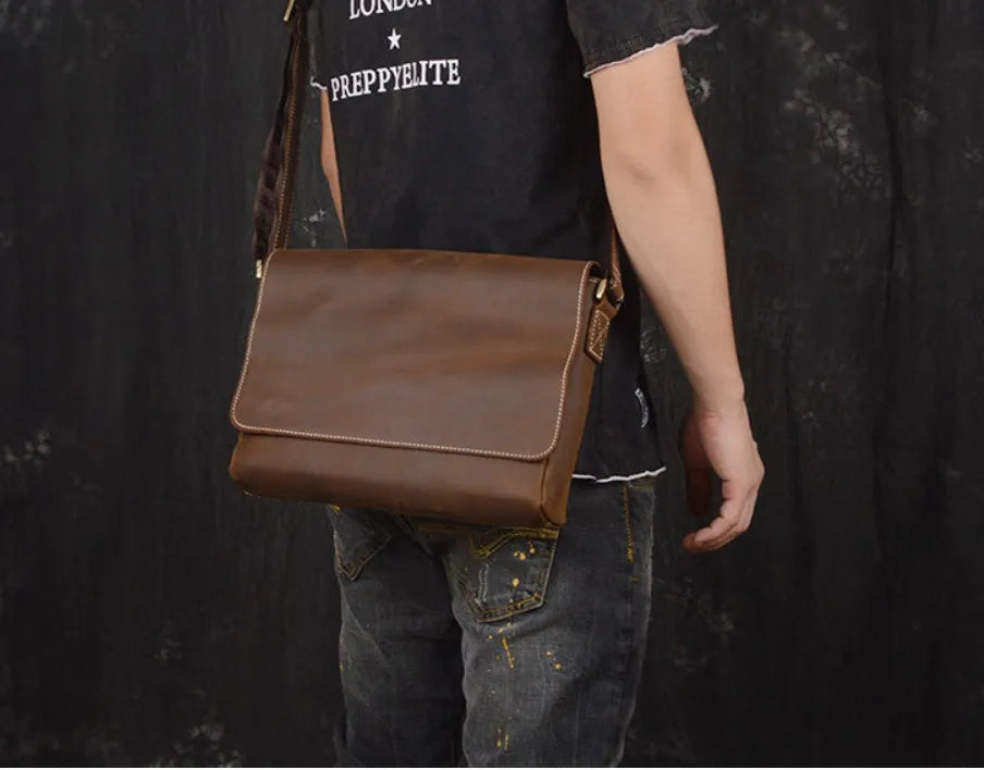 Men's vintage brown cowhide shoulder bag showing medium size and cross-body strap