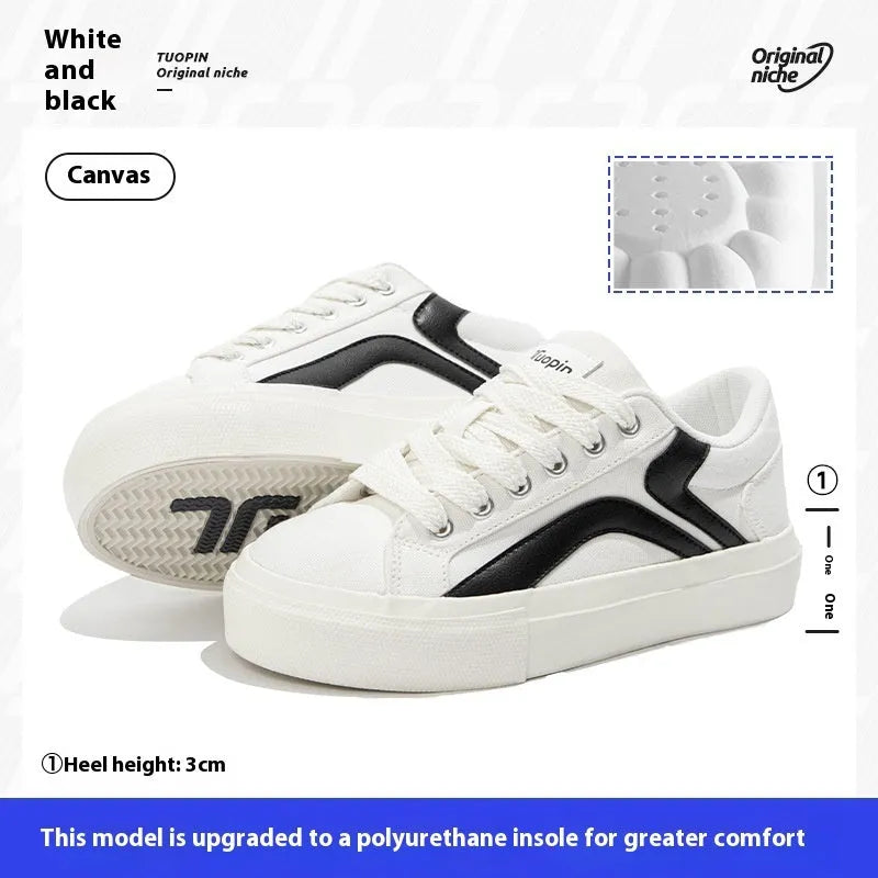 Women's low-top board shoes in a black and white colour combination, showing round toe and front lace-up design.