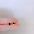 Black round mini ear studs in sterling silver plating with inlaid zircon on white background
