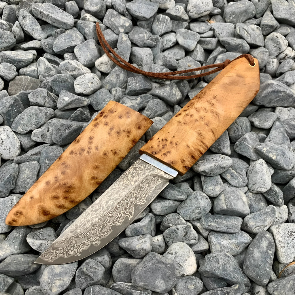 White Shadow Damascus steel short knife with Thuja wood handle, showing blade pattern.