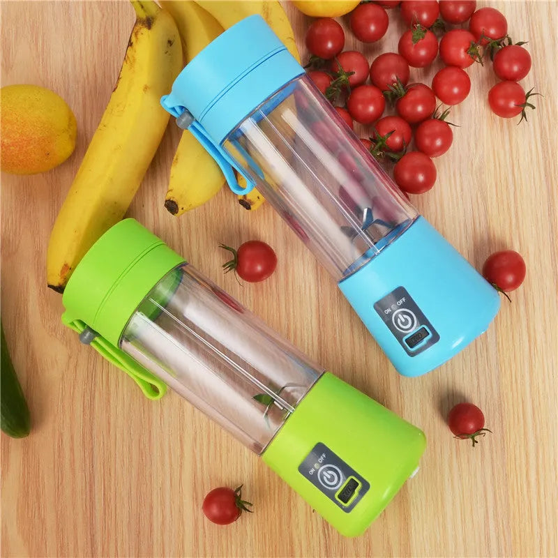 Pink mini USB electric centrifugal fruit juicer with stainless steel blade on a table.
