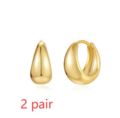 Geometric brass earclip earrings with a gold electroplated finish and round design details.