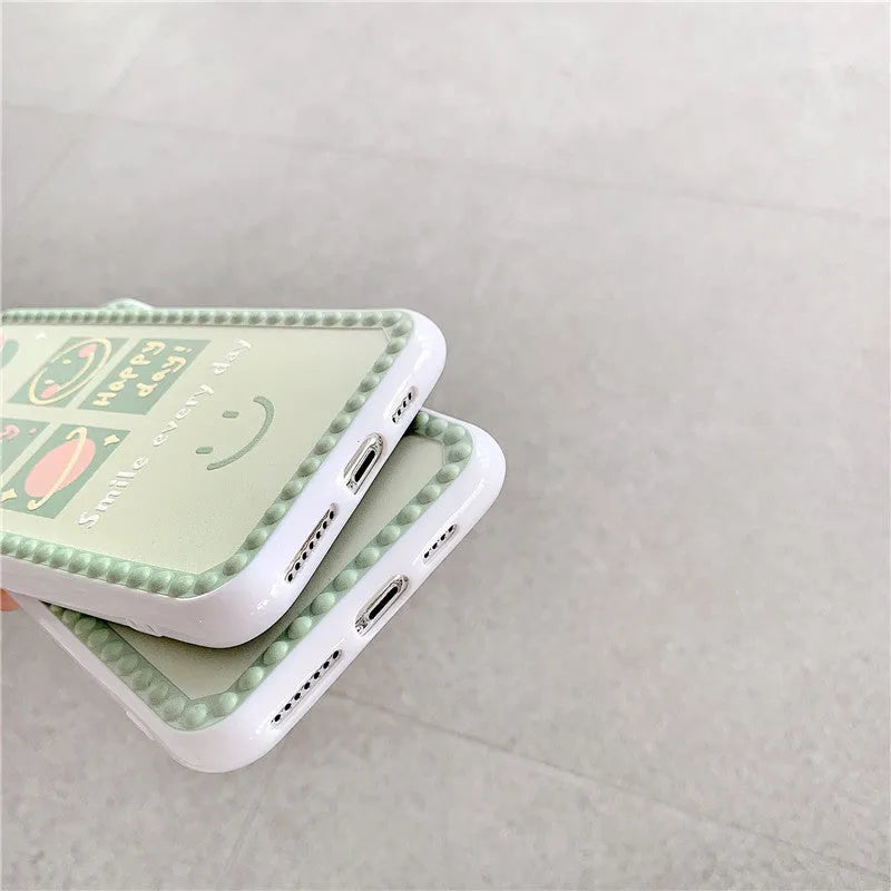 Green iPhone case with geometric smiley face and white polka dot design on a soft rubber TPU back cover.