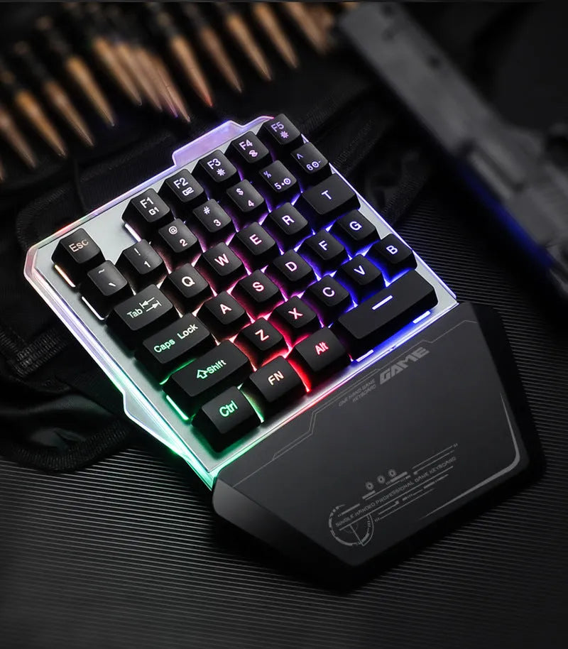 Black one-handed mechanical gaming keyboard with RGB backlit keys on a desk.
