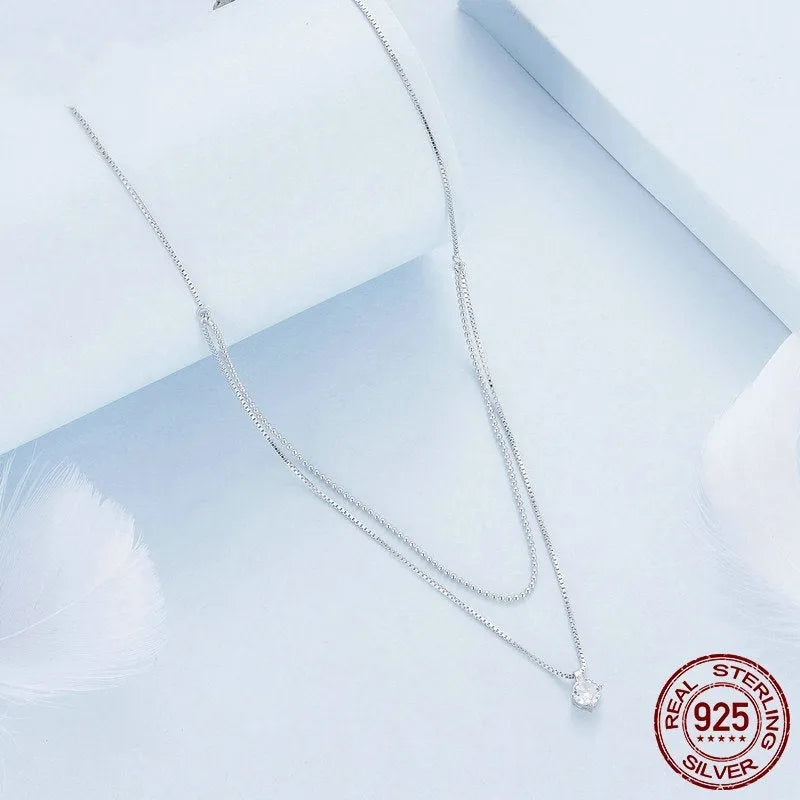 Close-up of a women's double-layer pearl chain necklace in S925 sterling silver with a shining pendant.