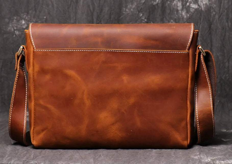 Men's vintage brown cowhide shoulder bag showing medium size and cross-body strap