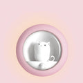 A white bedside sleep lamp for babies with orange, pink, and white light options and a projection feature on a nursery table.