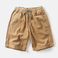 Man wearing khaki retro-style polyester cargo shorts with a straight leg fit for summer.