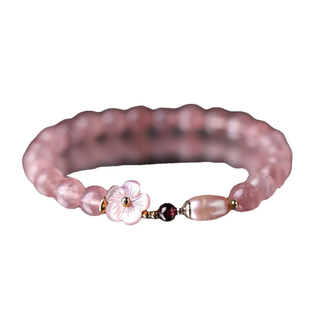 Strawberry quartz crystal bracelet with a peach blossom flower shape on a wrist.