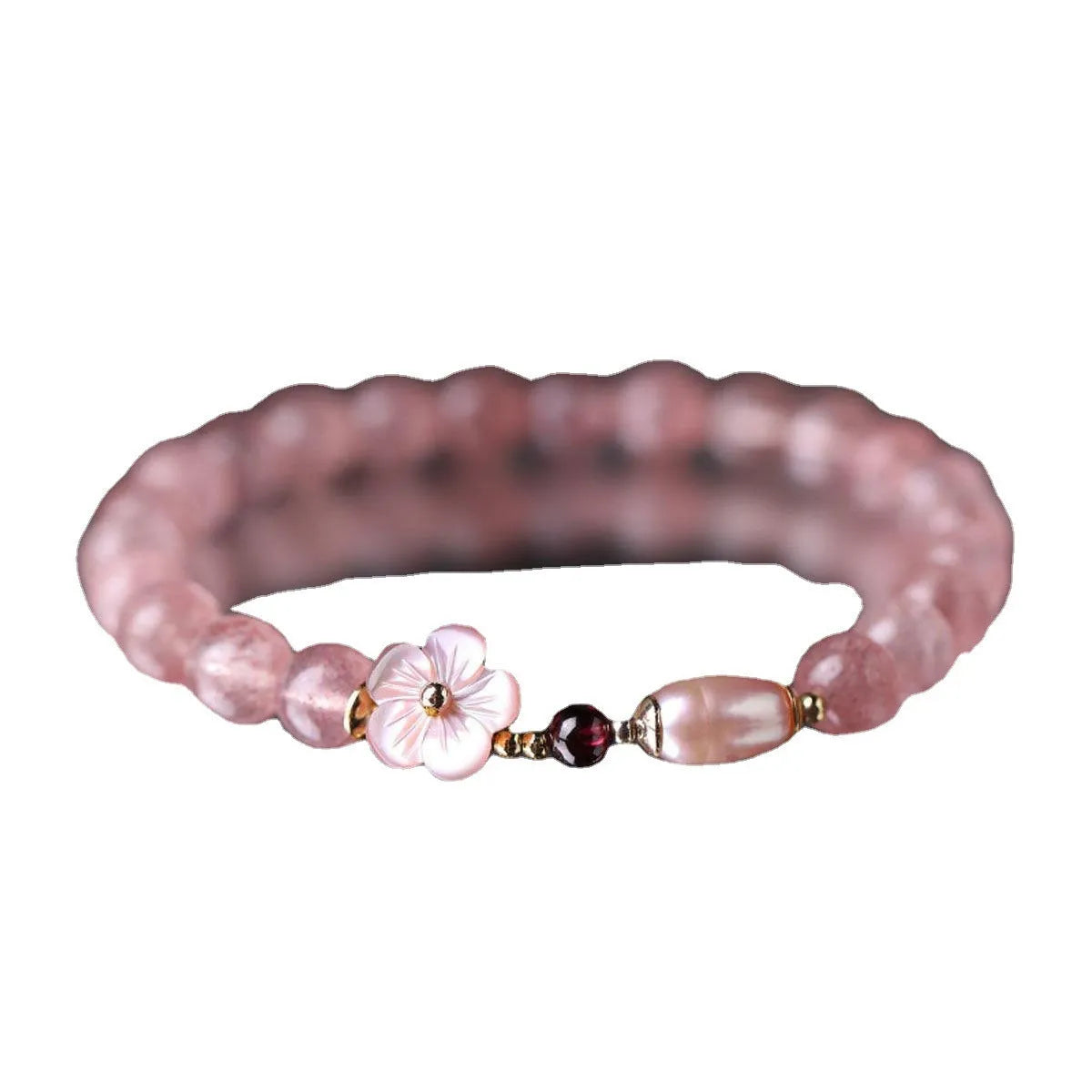 Strawberry quartz crystal bracelet with a peach blossom flower shape on a wrist.