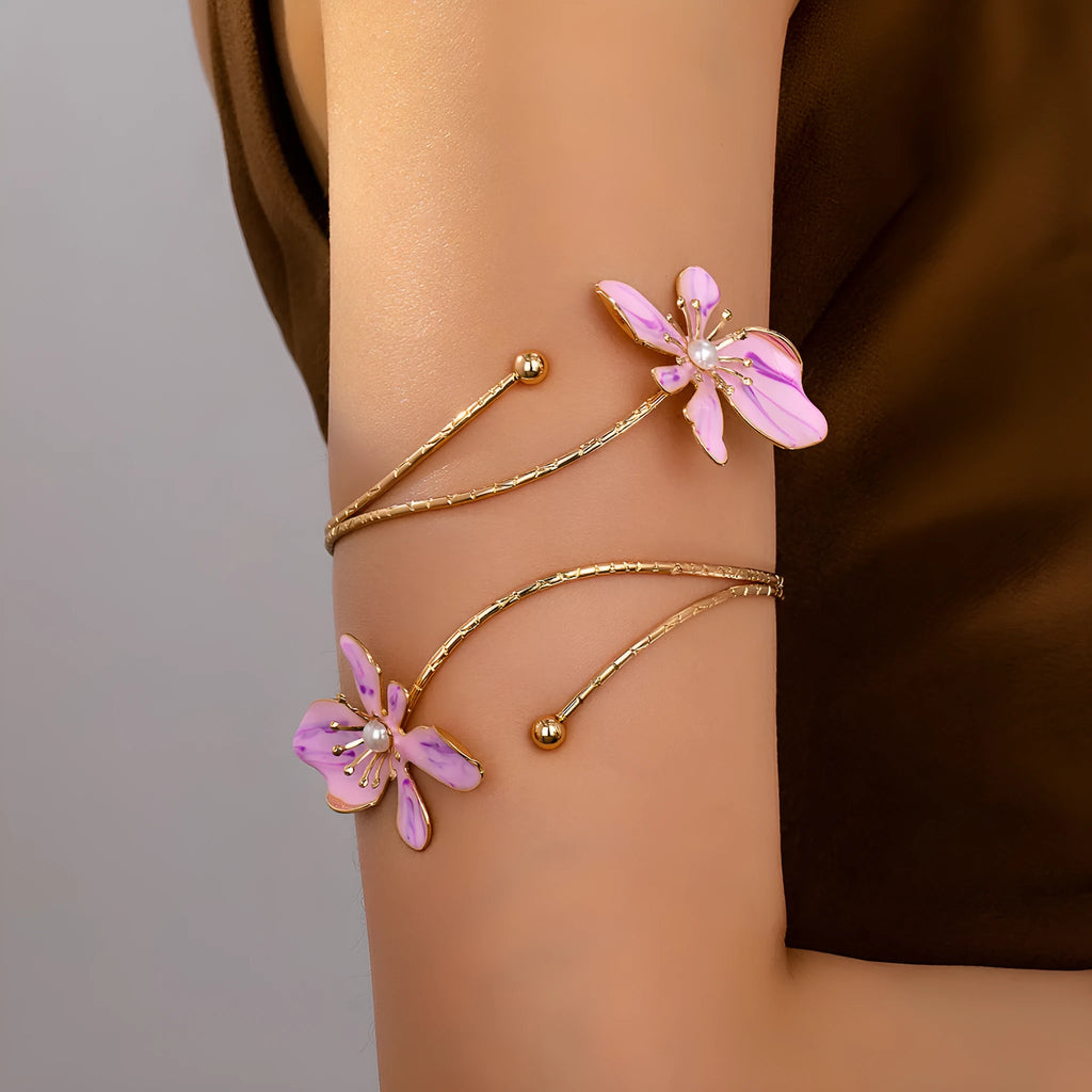 Close-up of a pink alloy armband with a hollow patterned design.