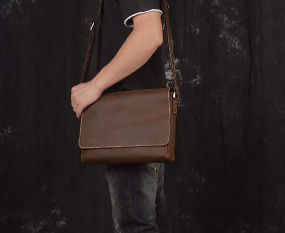 Men's vintage brown cowhide shoulder bag showing medium size and cross-body strap