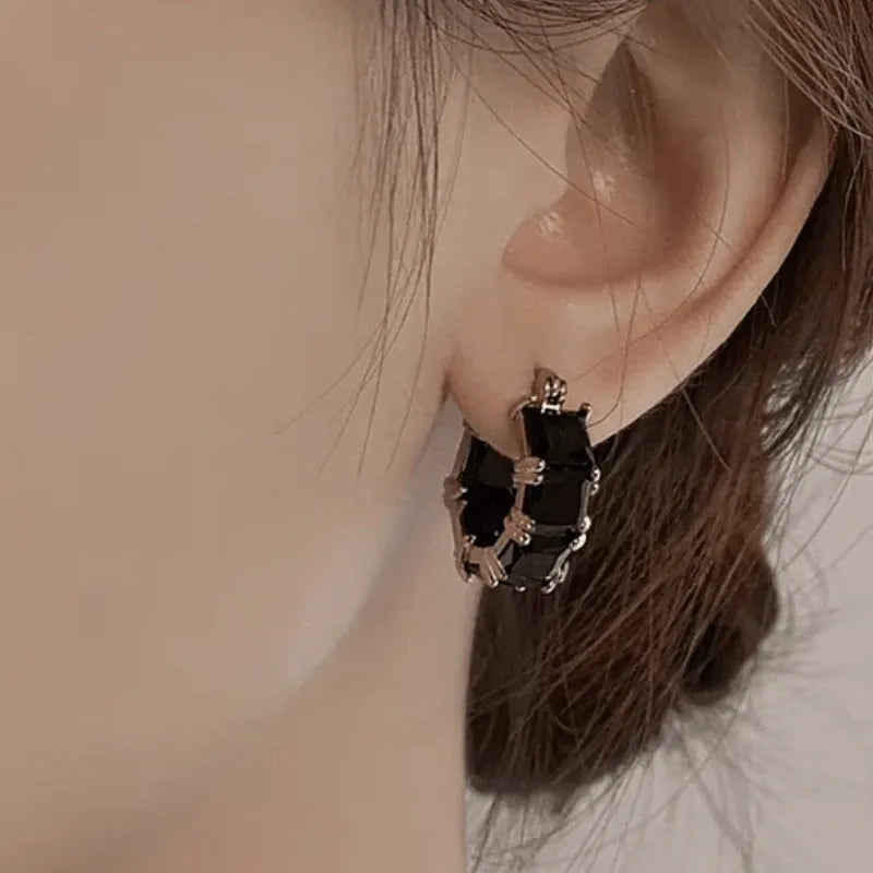 Geometric U-shaped drop earrings with zircon stones in black, pink or white colours on gold electroplated copper