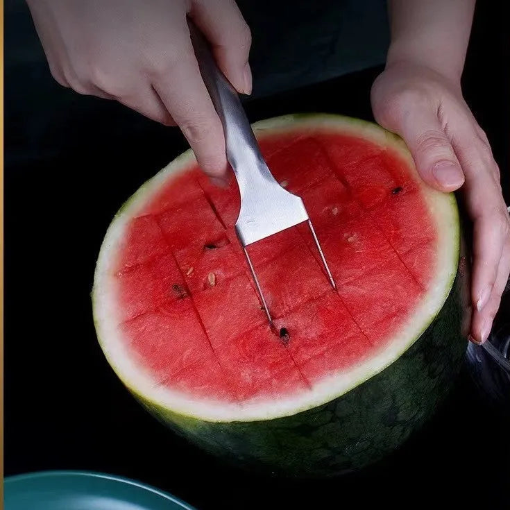 Silver stainless steel watermelon slicer and serving fork on a kitchen counter