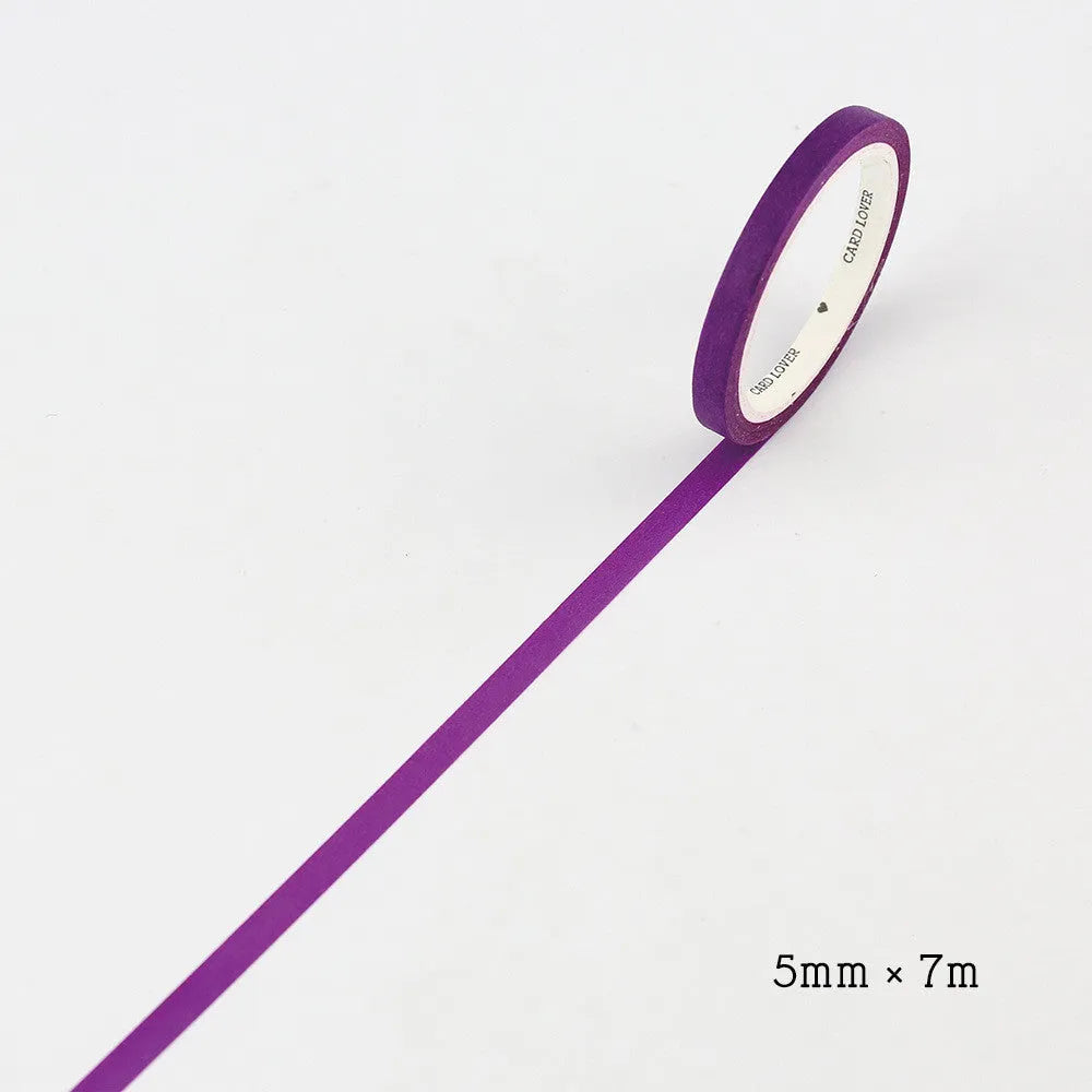 Close-up of narrow 5mm solid colour paper tape rolls in crimson and deep purple.