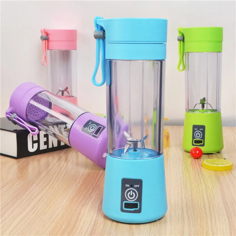 Pink mini USB electric centrifugal fruit juicer with stainless steel blade on a table.