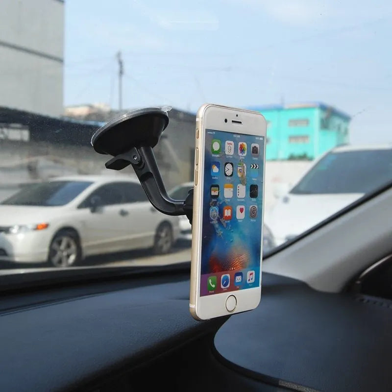 Black magnetic car phone holder mounted on a dashboard, showing a smartphone attached at an angle.