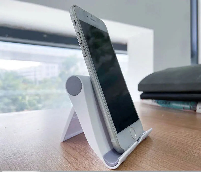 Black PE folding mobile phone stand holding a tablet at an angle on a desk