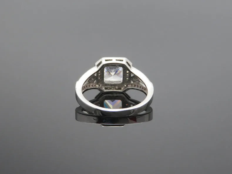 Geometric hollow zircon ring for women in platinum colour on copper, showing quadrilateral design and inlaid stones.