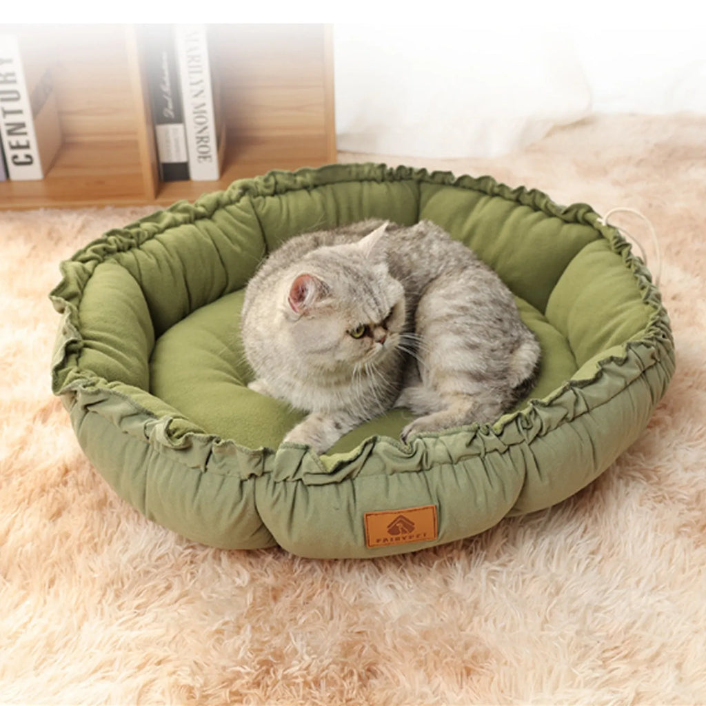 Grey reversible donut-shaped cat bed with raised rim, shown next to a green version of the same bed.