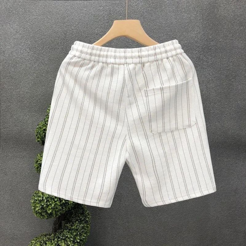Man wearing black and white striped casual shorts with an elastic waistband and banded ankles.
