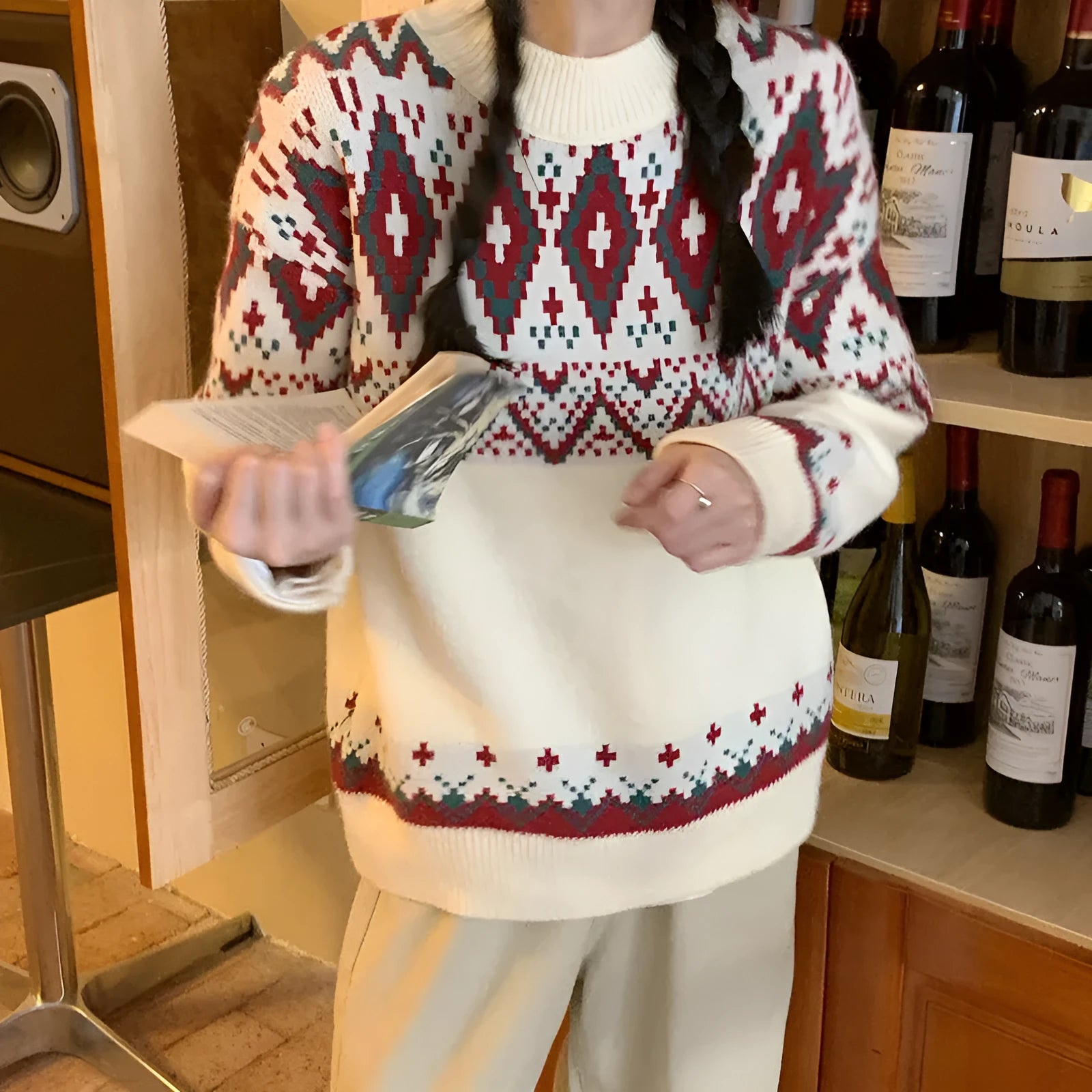 A woman wearing a loose red and white striped long-sleeved knitted pullover top.
