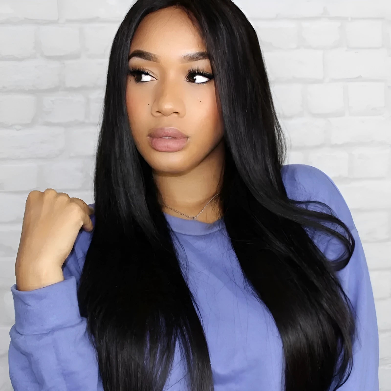 Long straight black synthetic wig with centre-parted bangs on a wig stand