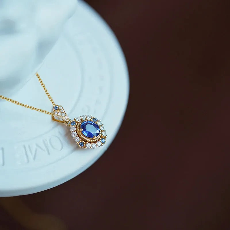 Golden women's necklace with a sparkling zircon inlaid gemstone pendant on an adjustable box chain.