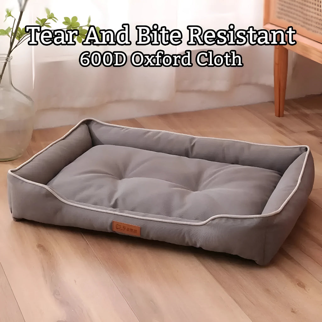 Gray luxury dog sofa bed with raised edges on a wooden floor, showing waterproof Oxford cloth and plush cushion.