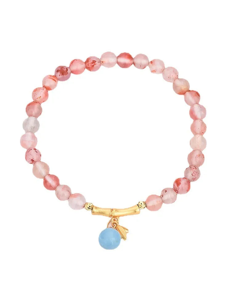 Ice float nanhong agate bracelet with floral shape and bamboo joint design on a wrist.