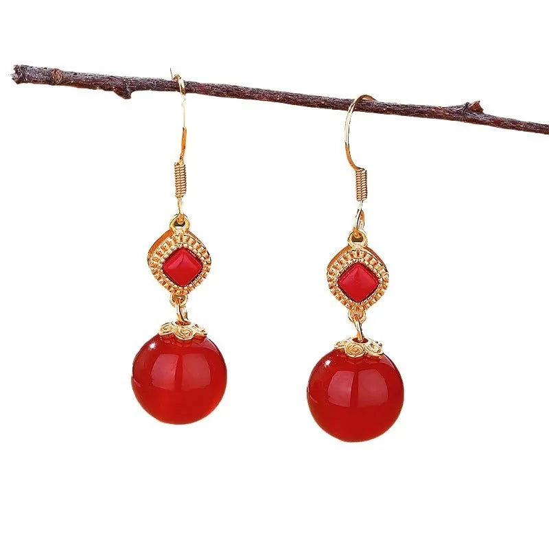 Geometric drop earrings with red agate round beads and sterling silver inlaid jasper stones on a copper base.