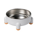 A green stainless steel pet bowl with a non-slip base and high foot, placed on a floor.