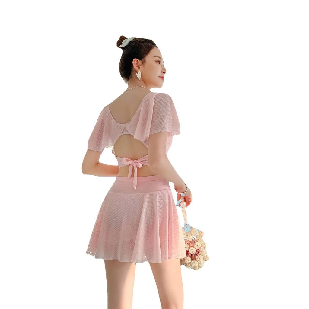 Women's solid colour two-piece swimsuit set with a top and split skirt.