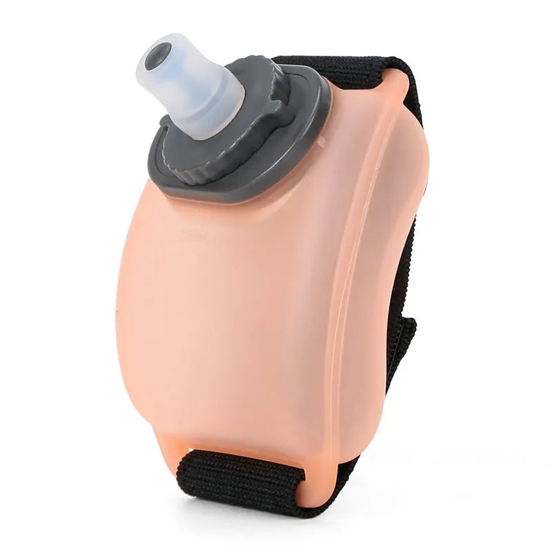 Orange wrist water bottle with Velcro strap shown secured around wrist during running activity