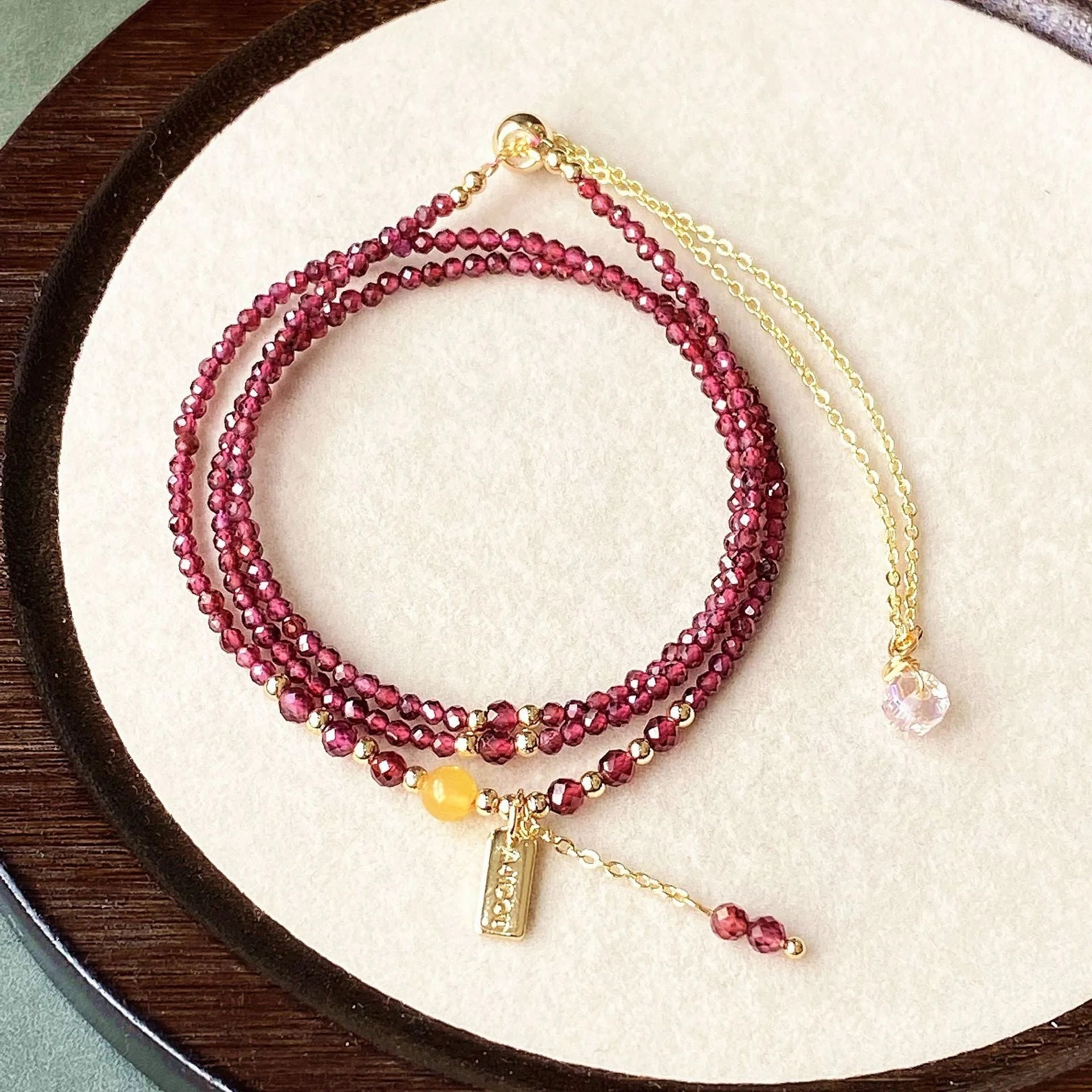 Wine red garnet bracelet with three circle design showing 2.5mm cut stone beads and electroplated metal