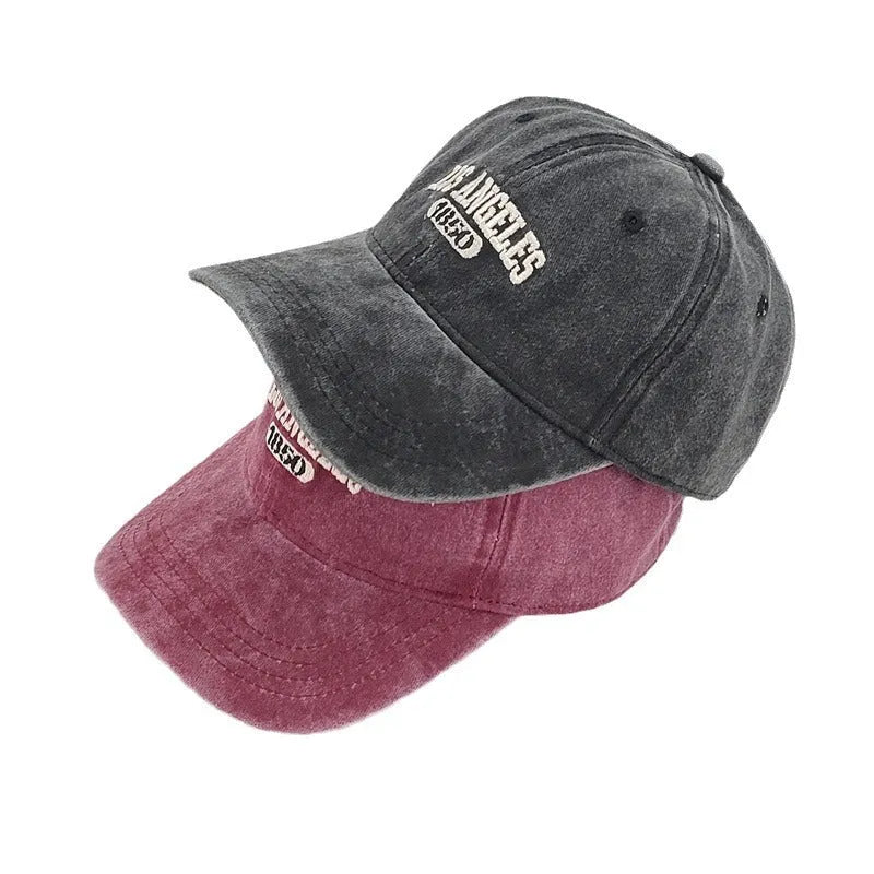 Retro distressed baseball cap with embroidered letters on the front, shown in a beige colour.