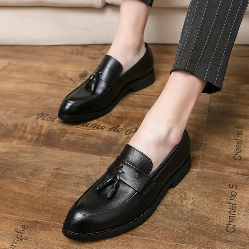 Men's black slip-on business casual shoes with a tassel detail on the front.