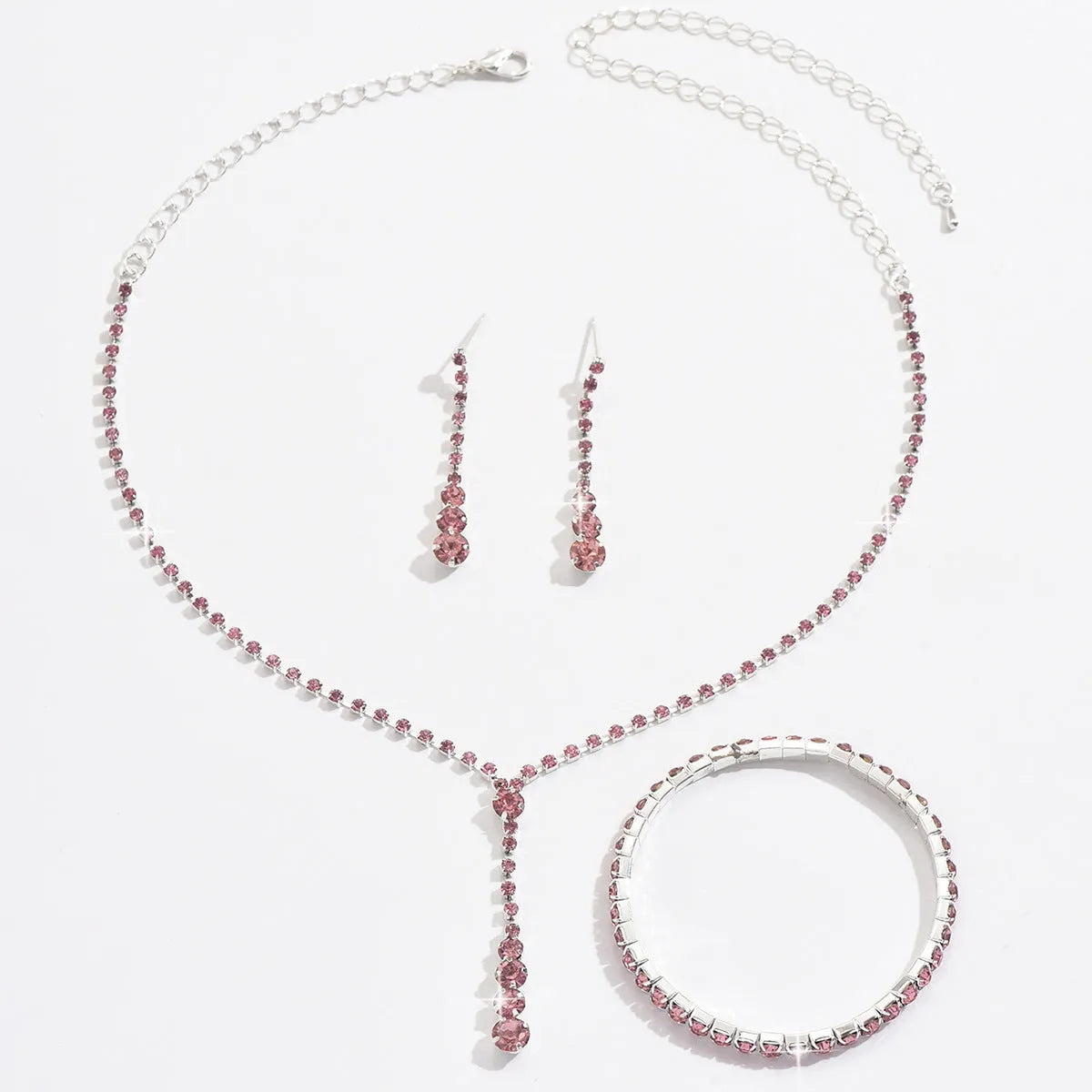 Women's rhinestone jewellery set with elastic bracelet, snake bone chain necklace, and earrings in rose gold finish.