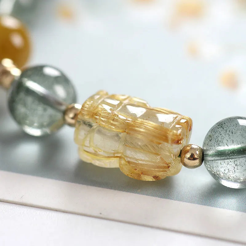 Green phantom quartz bracelet with 8mm geometric beads and gold rutile inclusions on wrist
